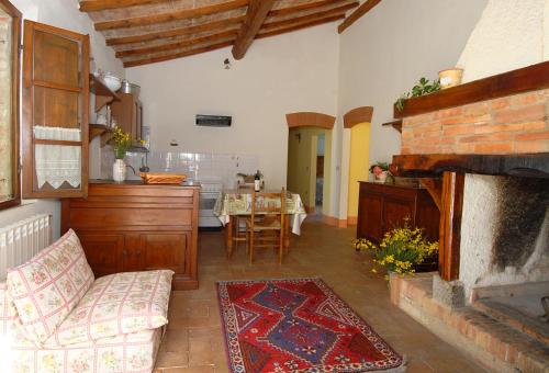 a living room with a fireplace and a kitchen with a table at Podere SantaAdele in Montepulciano