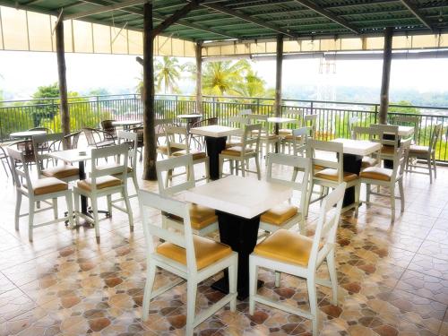 un restaurante con mesas y sillas en un balcón en LEOS Hotel, en Tomohon