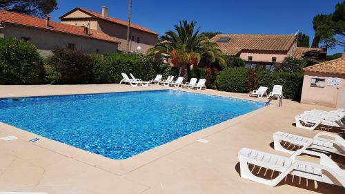 une piscine avec des chaises longues à côté d'une maison dans l'établissement Mes maisons à la Pinède, à Sainte-Maxime