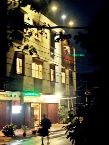 a person walking down a street in front of a building at LEOS Hotel in Tomohon