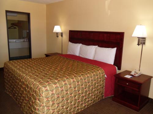 a hotel room with a large bed and two night stands at Budget Inn Flagstaff in Flagstaff