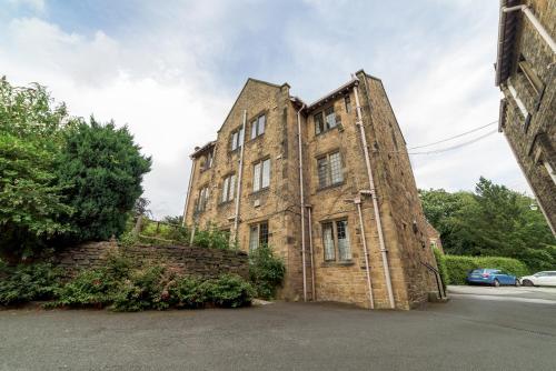 um velho edifício de tijolos sentado ao lado de uma rua em Mirfield Monastery B&B em Mirfield