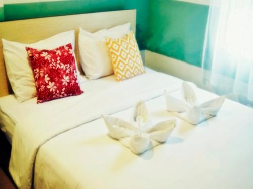 a bed with three white flowers on it at LEOS Hotel in Tomohon