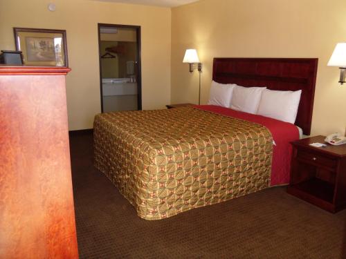 a hotel room with a bed with a red bedspread at Budget Inn Flagstaff in Flagstaff