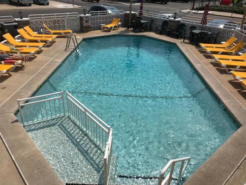 a large swimming pool with yellow chairs in a building at Starfire Motel in Wildwood