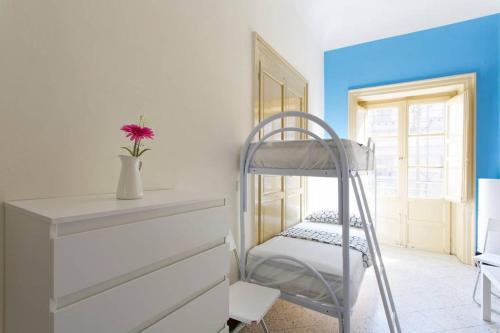 a room with a bunk bed and a ladder at Sunshine Hostel Palermo in Palermo