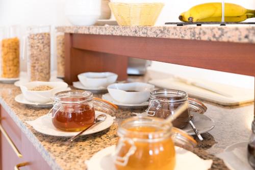 a kitchen counter with jars of honey and bowls of food at CityHotel Uelzen in Uelzen