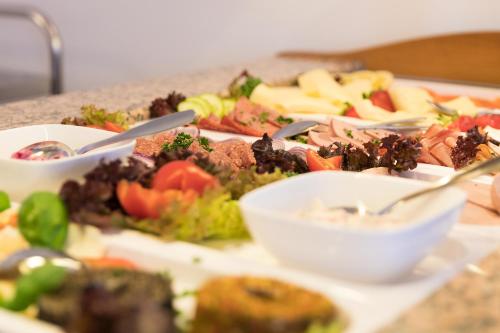 a table with a bunch of plates of food at CityHotel Uelzen in Uelzen