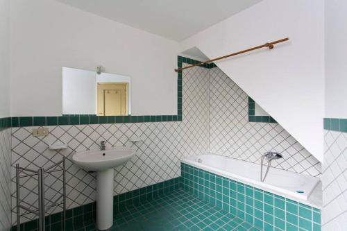 a bathroom with a sink and a bath tub at Sunshine Hostel Palermo in Palermo