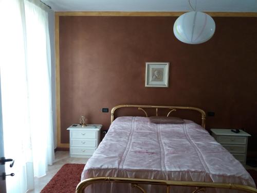 カステルヌオーヴォ・デル・ガルダにあるCasa Caterinaの茶色の壁のベッドルーム1室(ベッド1台付)