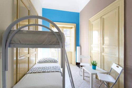 um pequeno quarto com um beliche e uma mesa em Sunshine Hostel Palermo em Palermo