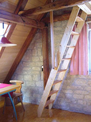 a wooden staircase in a room with a stone wall at Ferienwohnungen Taubenschlag in Creglingen