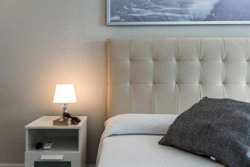 a bedroom with a bed with a white headboard and a lamp at Lagos Village in Lagos