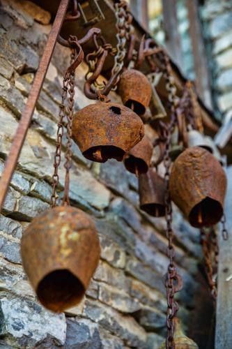 a bunch of rusty objects hanging on a stone wall at Arxontiko Agonari in Metamorfosi