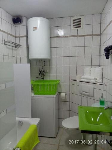 a bathroom with green baskets on top of a toilet at R&G Pineda Apartamento in La Pineda