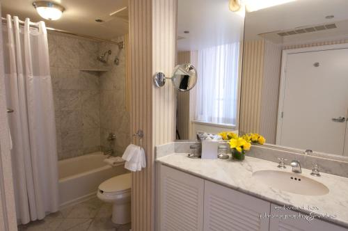 a bathroom with a sink and a toilet and a tub at Warwick Allerton Chicago in Chicago