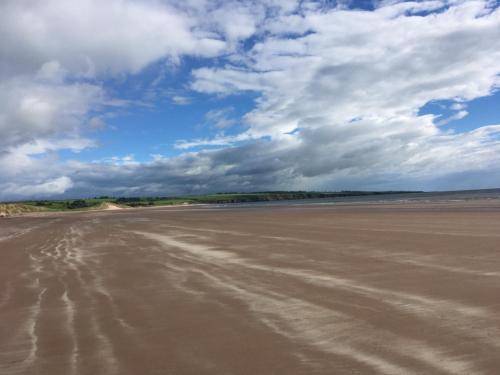 an empty beach under a cloudy sky at Balnabrechan Lodge in Arbroath