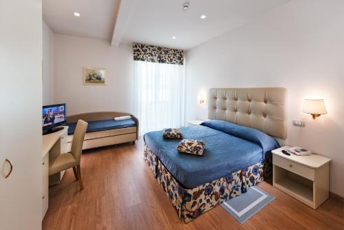 a bedroom with a bed and a desk with a computer at Hotel Bahia in San Benedetto del Tronto