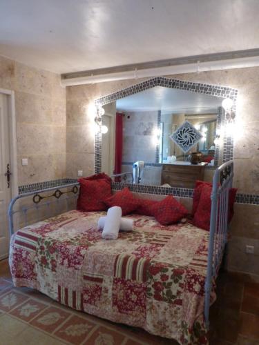 a bedroom with a large bed with a large mirror at Mas de la Chapelle in Arles