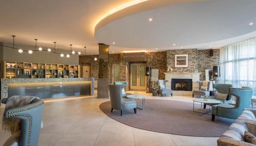 a lobby with couches and chairs and a fireplace at Harbour Hotel in Galway