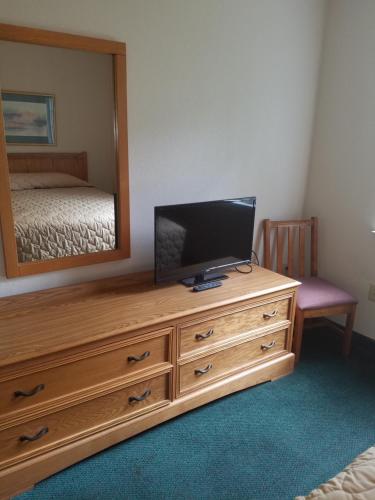 a bedroom with a television on a dresser with a mirror at Affordable Suites Gastonia in Gastonia