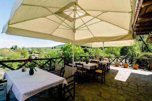 a restaurant with tables and a large umbrella at Arxontiko Agonari in Metamorfosi