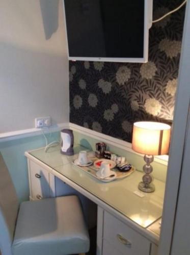 a desk with a lamp and a plate of food on it at Alma Lodge Guest House in Plymouth
