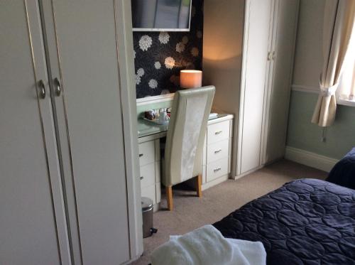 a bedroom with a desk and a bed and a chair at Alma Lodge Guest House in Plymouth