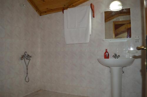 een witte badkamer met een wastafel en een douche bij Erasmus Apart Hotel in Dalyan
