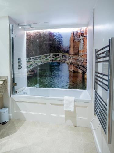 a bathroom with a window with a view of a bridge at Gonville Hotel in Cambridge