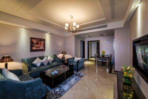 a living room with blue couches and a television at Boudl Al Woroud بودل الورود in Riyadh