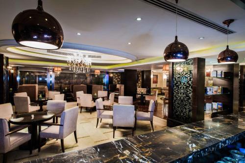 a restaurant with a bar with chairs and tables at Boudl Al Woroud بودل الورود in Riyadh