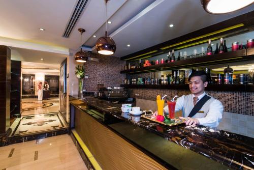 a man standing behind a bar in a restaurant at Boudl Al Woroud بودل الورود in Riyadh