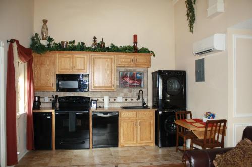 a kitchen with wooden cabinets and a black appliances at Woodrow House Bed & Breakfast in Lubbock