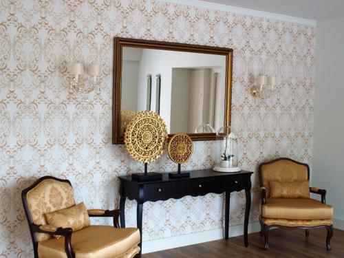 a room with a mirror and two chairs and a desk at Luna Hotel Turismo in Abrantes