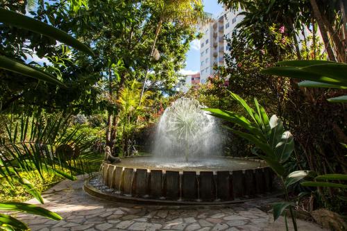 a fountain in the middle of a garden at Hotel Parque Das Primaveras in Caldas Novas