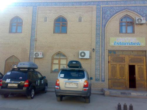 two cars parked in a parking lot in front of a building at Islambek Hotel & Travel in Khiva