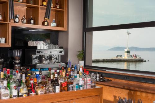 a bar with a bunch of bottles on a counter at Angelica Hotel in Limenas