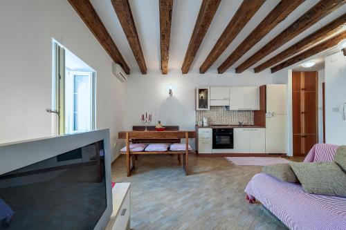 a living room with a tv and a kitchen at Apartmani Aligator in Primošten