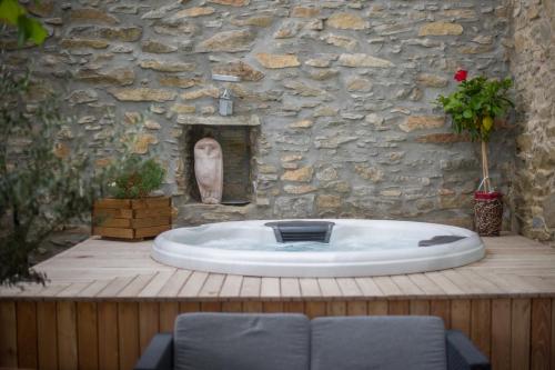 a bath tub in front of a stone wall at La Belle Minervoise in Saint-Frichoux