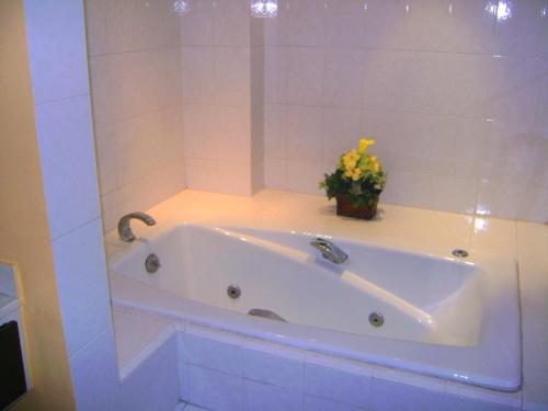 a white tub in a bathroom with a vase of flowers at Hotel Le-Gar in Monterrey