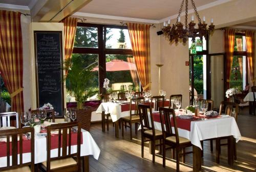 a dining room with tables and chairs in a restaurant at Nierswalder Landhaus in Goch