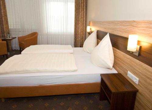 a hotel room with two beds and a table at Nierswalder Landhaus in Goch