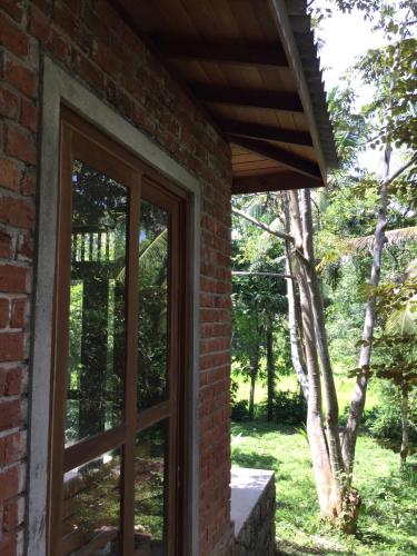 a window in a brick house with a tree at Eco Breeze - Unawatuna in Unawatuna