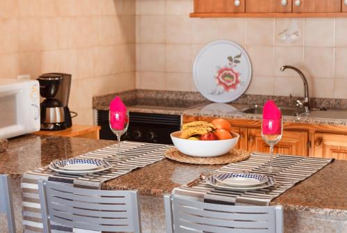 a kitchen with two wine glasses and a bowl of fruit at Apartamento Filla in Puerto del Carmen