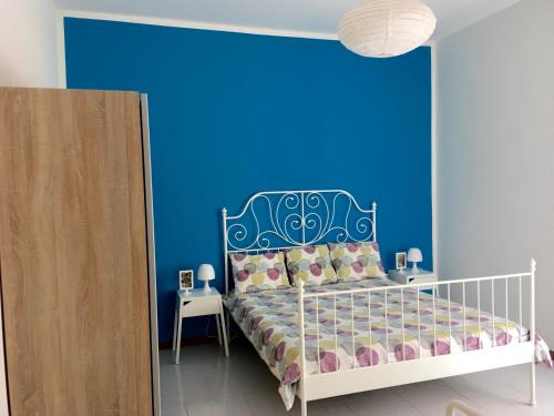 カステルサルドにあるAppartamento Aria 150m dal mareの青い壁のベッドルーム1室、ベッド1台が備わります。
