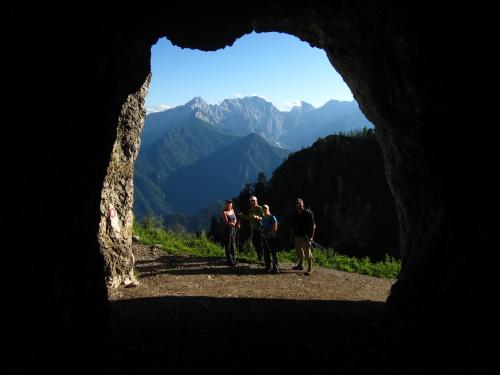 a group of people walking through a cave in the mountains at Boutique rooms Pri Rogovilcu in Solčava