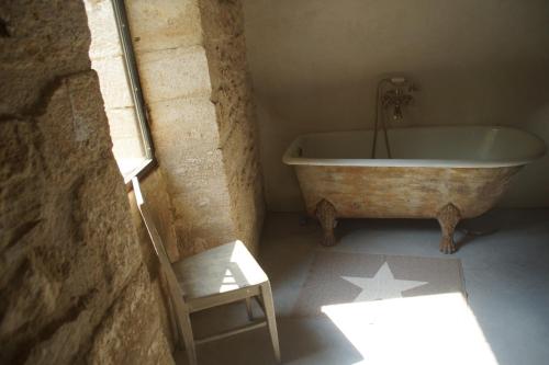 La salle de bains est pourvue d'une baignoire et d'une chaise. dans l'établissement Uzes, loft dans Moulin independant 18e siecle en bord de riviere piscine privee 15x3, à Uzès