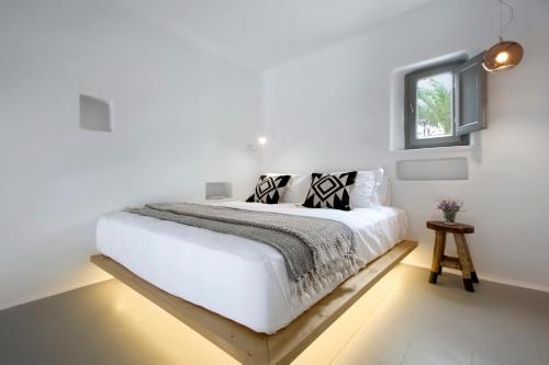 a bedroom with a white bedspread and white pillows at Dreambox Mykonos Suites in Ornos