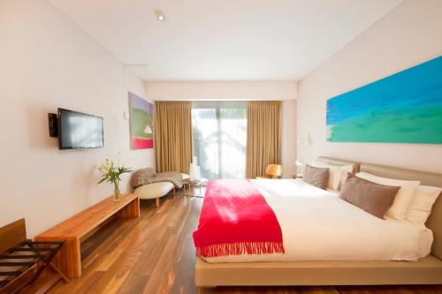 a bedroom with a large bed and a television at Palo Santo Hotel in Buenos Aires